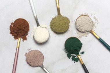 Sağlık ve güzellik için farklı beslenme malzemeleri - kolajen, vitamin, biyotin, kaşıklardaki protein tozu