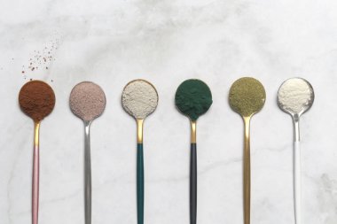 Sağlık ve güzellik için farklı beslenme malzemeleri - kolajen, vitamin, biyotin, kaşıklardaki protein tozu