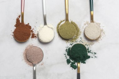 Sağlık ve güzellik için farklı beslenme malzemeleri - kolajen, vitamin, biyotin, kaşıklardaki protein tozu