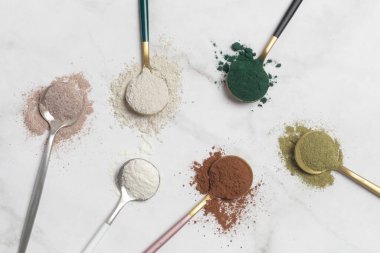 Sağlık ve güzellik için farklı beslenme malzemeleri - kolajen, vitamin, biyotin, kaşıklardaki protein tozu