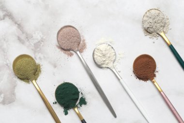 Sağlık ve güzellik için farklı beslenme malzemeleri - kolajen, vitamin, biyotin, kaşıklardaki protein tozu