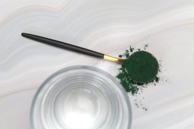 Kaşıkta yeşil toz, spirulina, alage, klorofil veya kibrit. Besin takviyesi, diyet, detoks, önleyici sağlık ve sağlıklı yaşam tarzı kavramı.