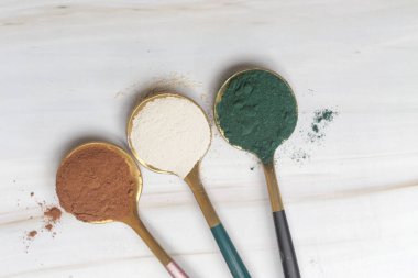 Sağlık ve güzellik için farklı beslenme malzemeleri - kolajen, vitamin, biyotin, kaşıklardaki protein tozu