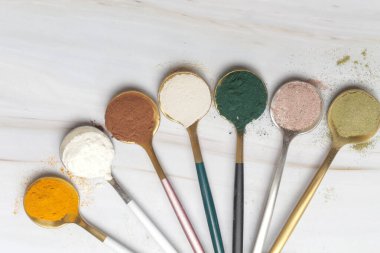 Sağlık ve güzellik için farklı beslenme malzemeleri - kolajen, vitamin, biyotin, kaşıklardaki protein tozu