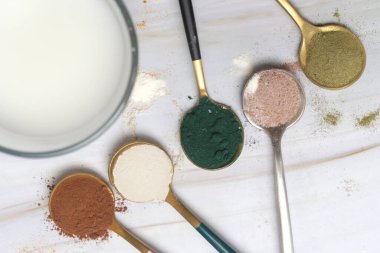 Sağlık ve güzellik için farklı beslenme malzemeleri - kolajen, vitamin, biyotin, kaşıklardaki protein tozu