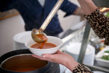 Açık büfeden çorba alan bir kadın.