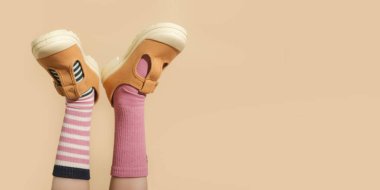 Çocuk farklı bir çift çorap giyiyor. Uyumsuz çoraplar içinde çocuk ayakları, fotokopi çekilen stüdyo fotoğrafları. Down sendromu farkındalık konsepti, garip çoraplar günü, zorbalık karşıtı hafta.