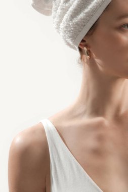 Beyaz pamuklu sutyen, pantolon ve havluyla stüdyoda poz veren güzel bir kadın. Pozitif ve mutlu bir bayanın sabah keyfi. Refah ve kendine bakım kavramı.