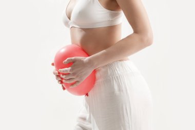 Young woman holding balloon as a sign of an stomach inflation, bloating and menstrual cramps concept clipart