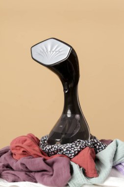 Kalın giysili vapur. Dikey vapuru ütüye hazır kıyafetlerle kapatın. Hızlı ve kolay ütüleme kavramı. 