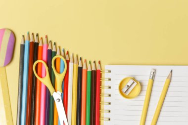 Sarı arka planda çeşitli ofis ve okul malzemeleriyle okul konseptine geri dönelim..