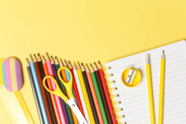 Sarı arka planda çeşitli ofis ve okul malzemeleriyle okul konseptine geri dönelim..