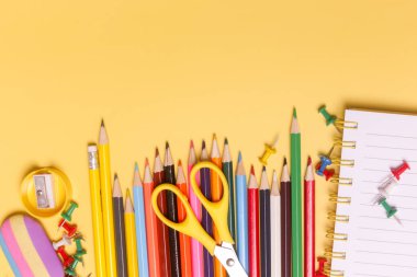 Sarı arka planda çeşitli ofis ve okul malzemeleriyle okul konseptine geri dönelim..