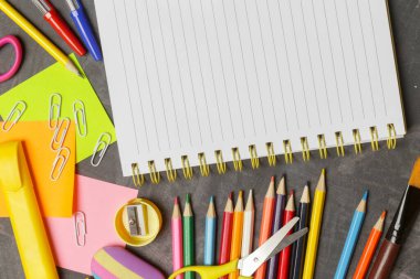 Siyah karatahta arka planında çeşitli ofis ve okul malzemeleriyle okul konseptine geri dönelim..