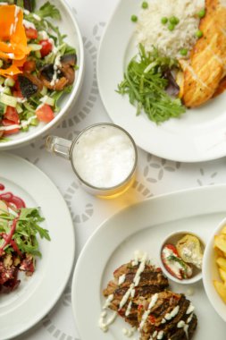 Restoran masasında çeşitli lezzetli yemekler servis ediliyor.