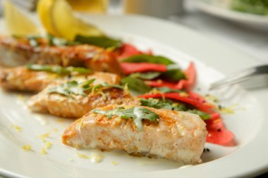 Restoran masasında salamura edilmiş sebzeli ızgara somon filetosu.