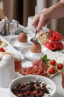 Genç bayan çeşitli yemek seçenekleriyle otel kahvaltısından zevk alıyor.