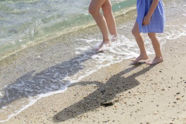 Kumsalda anne ve çocuğun çıplak ayakları..