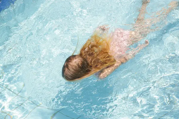 Küçük sevimli kız tatil köyü havuzunda eğleniyor. Yaz tatili kavramı