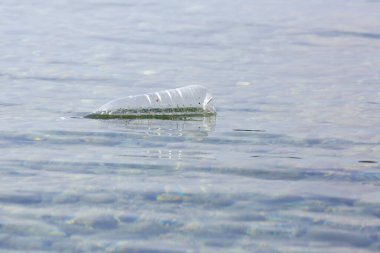 Okyanusta plastik bir şişe. Plastik kirliliği kavramı. Tek kullanımlık plastik gezegenimizi yok eden ve sularımızı, deniz yaşamlarımızı ve insanlarımızı etkileyen bir insan bağımlılığıdır..