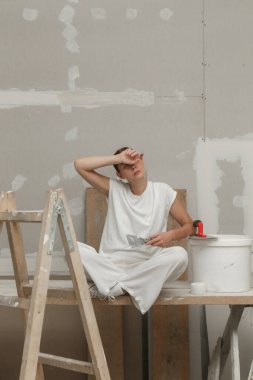 Tired and frustrated women resting during home renovation work, taking a break during DIY home improvement project.