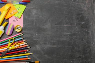 Siyah karatahta arka planında çeşitli ofis ve okul malzemeleriyle okul konseptine geri dönelim..