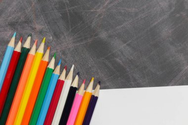 Boş çizgili defter ve tahta renkli kalemlerle okul konseptine geri dönelim.