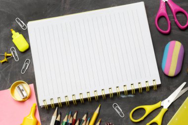 Siyah karatahta arka planında çeşitli ofis ve okul malzemeleriyle okul konseptine geri dönelim..