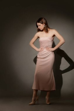 Stüdyo fotoğrafları, zarif bej askısız Maxi elbise giymiş kadın modeller.