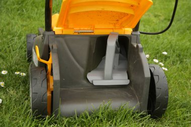 Çim biçme makinesinin, kırpma tıkaçlı resmini kapat. Kırpma işlevi, kırpmaları ince ince parçalara ayırır ve gübre olarak yere yayar..