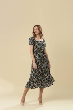 Stüdyo fotoğrafları. Siyah-beyaz, kısa kabarık kollu Midi elbiseli genç bir kadın model.