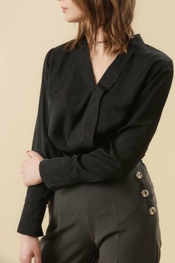 Stüdyo fotoğrafları, basit rahat iş kıyafetleri, pamuk siyah gömlek ve gri pantolon giyen genç kadın modeller.