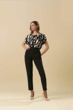 İpek bluz giyen kadın model ve şık siyah pantolon giyiyor. Moda stüdyosu çekimi.