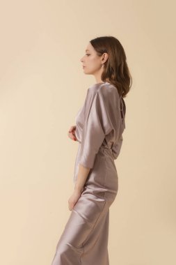 Tek renkli ipek elbise giyen bir kadın model. Klasik ve zamansız basit bluz ve midi etek. Moda stüdyosu çekimi.