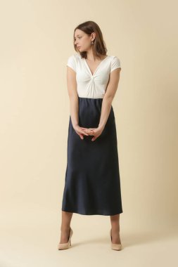 Beyaz yaz bluzu ve mavi ipek etek giyen kadın model. Moda stüdyosu çekimi.