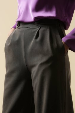 Gri, akıllı iş pantolonu giyen bir kadın model. Stüdyo çekimi.