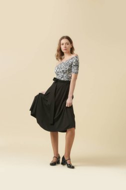 Hayvan desenli gömlek ve siyah midi etek giyen kadın model. Moda stüdyosu çekimi.