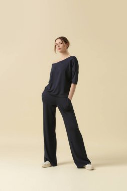 Loungewear pamuk giyen kadın model yumuşak ve rahat kıyafet, siyah bluz ve pantolon. Klasik ve basit moda. Stüdyo çekimi.