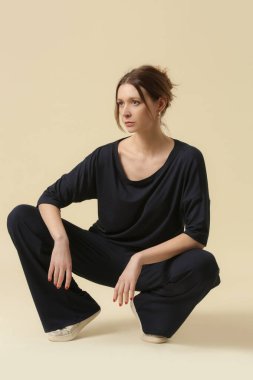 Loungewear pamuk giyen kadın model yumuşak ve rahat kıyafet, siyah bluz ve pantolon. Klasik ve basit moda. Stüdyo çekimi.