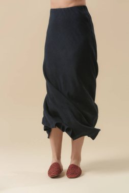 Stüdyo fotoğrafları, keten etekli genç bir kadın model. Sıradan ve şık kıyafetler, temel moda ürünleri, bahar-yaz moda trendi..