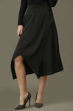 Zamansız siyah bir etek giyen kadın model. Moda stüdyosu çekimi.