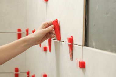 Banyo duvarlarını döşeyen kadın. Düz duvar plastik döşeme sistemi. Banyoya fayans döşeme işlemi. DIY Ev Geliştirme.