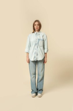 Modern gündelik kıyafet, kot pantolon, beyaz atlet ve kot tişört giymiş bir kadının seri fotoğrafları..