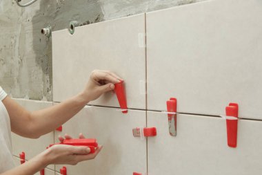 Banyo duvarlarını döşeyen kadın. Düz duvar plastik döşeme sistemi. Banyoya fayans döşeme işlemi. DIY Ev Geliştirme.