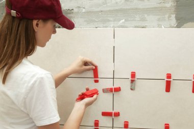 Banyo duvarlarını döşeyen kadın. Düz duvar plastik döşeme sistemi. Banyoya fayans döşeme işlemi. DIY Ev Geliştirme.