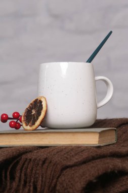 Sıcak kış yaşam tarzı konsepti. Eski bir kitapla sıcak bir bardak içki ve kalın örgülü kıyafetler..