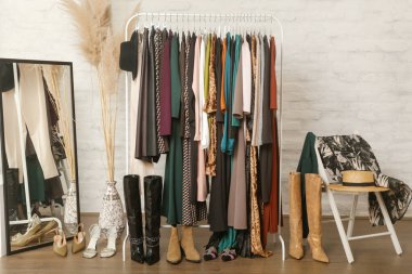 Kadın kıyafetleri ve ayakkabıları. Moda atölyesinde şık ve şık giysilerle elbise askısı. Kaliteli, zamansız moda eserleri. 