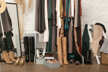 Kadın kıyafetleri ve ayakkabıları. Moda atölyesinde şık ve şık giysilerle elbise askısı. Kaliteli, zamansız moda eserleri. 