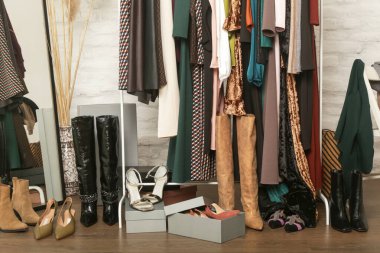 Kadın kıyafetleri ve ayakkabıları. Moda atölyesinde şık ve şık giysilerle elbise askısı. Kaliteli, zamansız moda eserleri. 