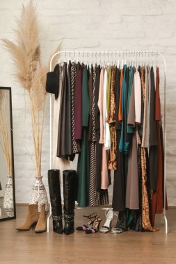 Kadın kıyafetleri ve ayakkabıları. Moda atölyesinde şık ve şık giysilerle elbise askısı. Kaliteli, zamansız moda eserleri. 